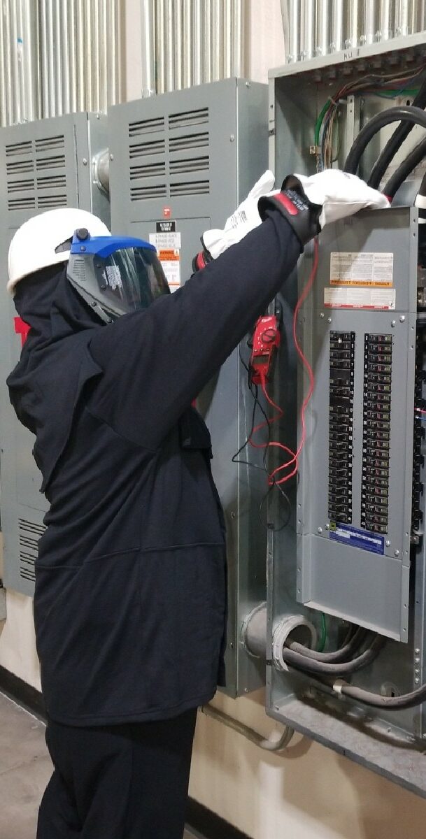 A Jenco electrical technician performs preventative maintenance on an electrical box